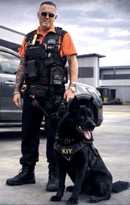 Security handler with K9 unit and patrol vehicle